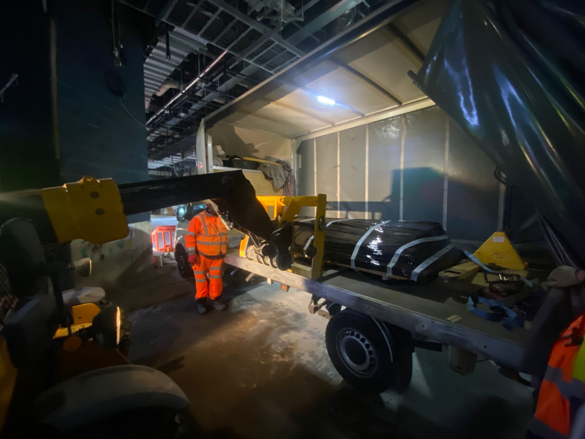 Night-time offload by telehandler at a covered construction site
