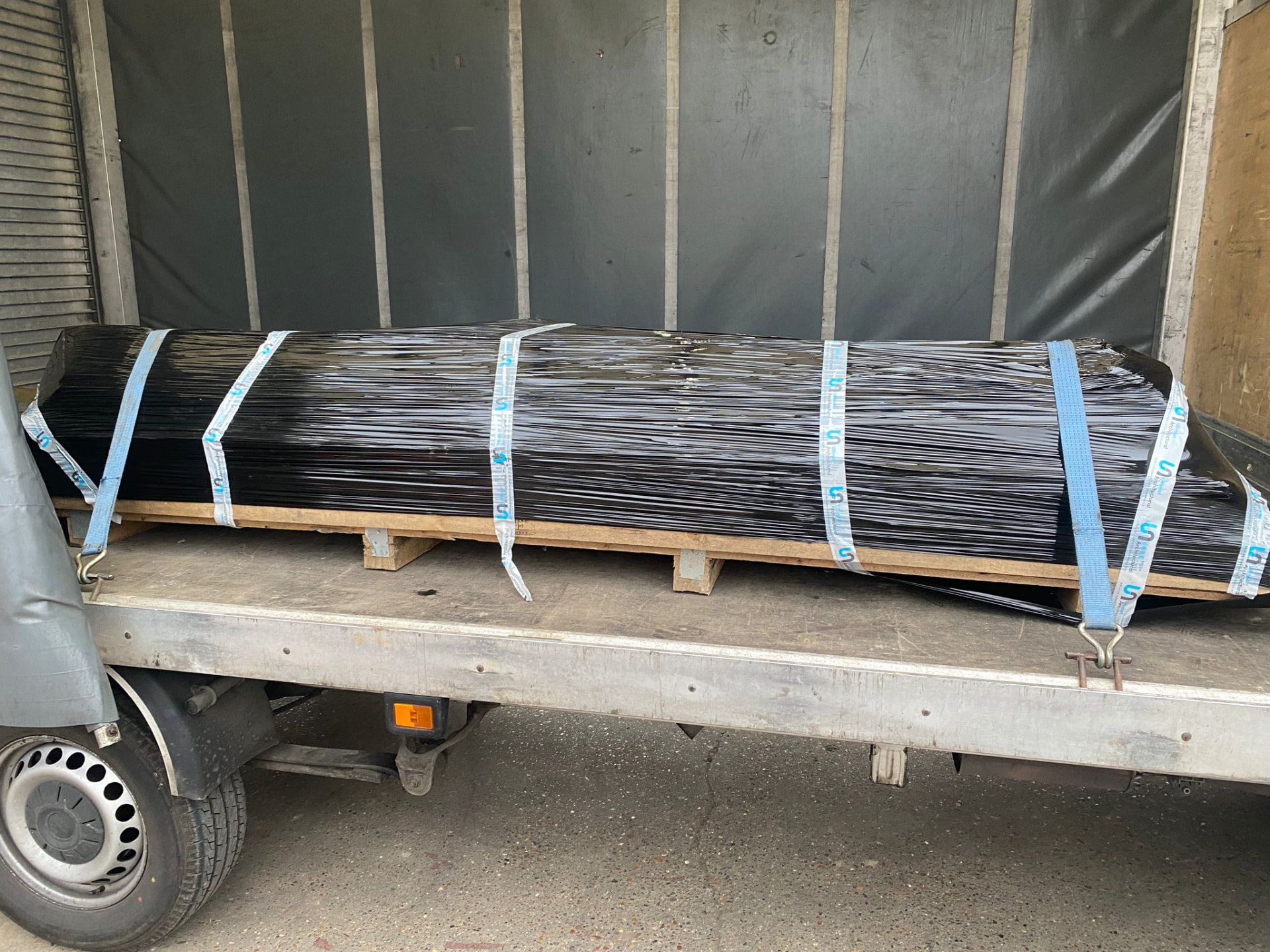 Long load stretch-wrapped and strapped in a curtain-sider