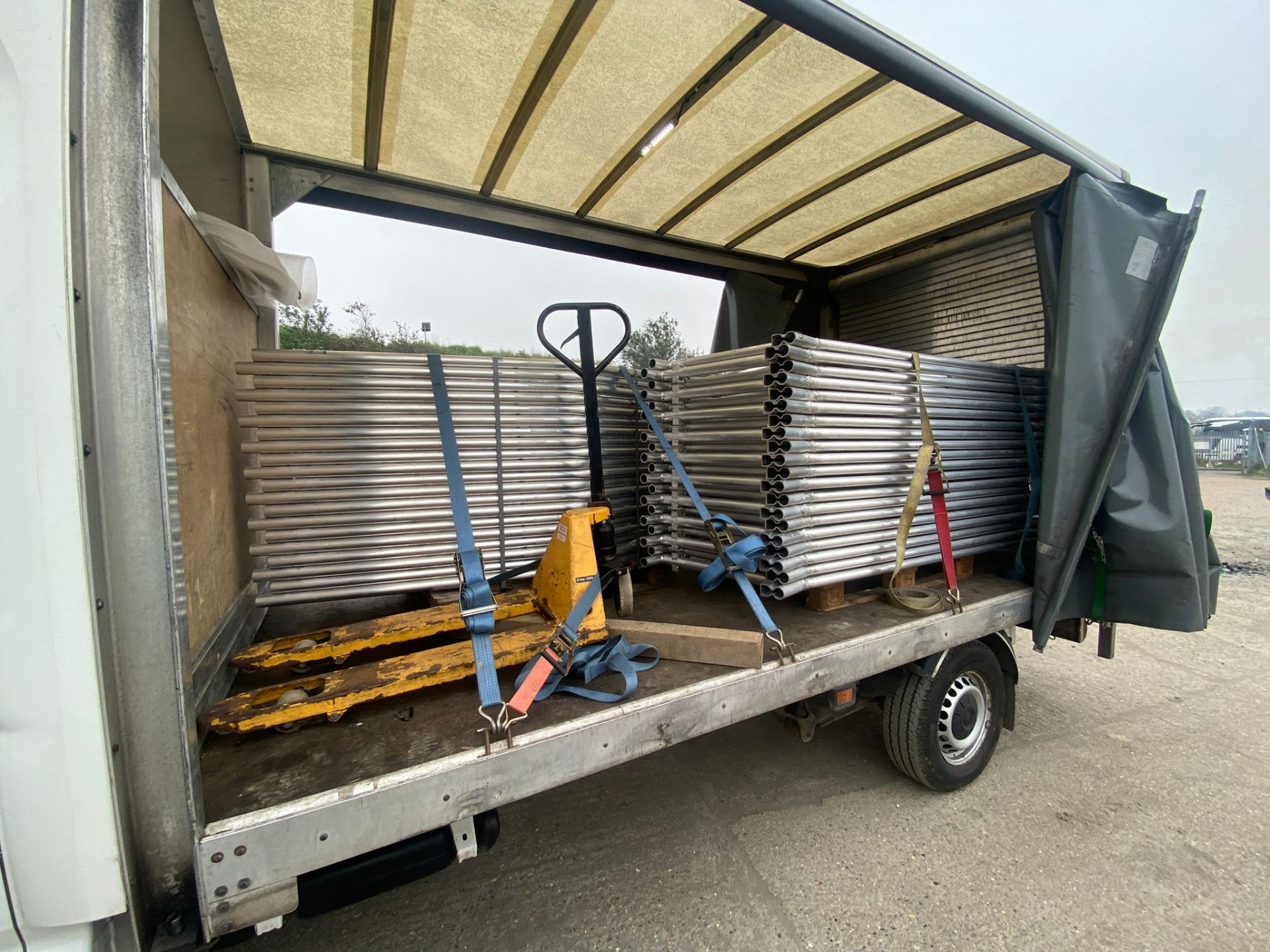 Curtain-sided tail-lift loaded with strapped site fencing and pallet truck