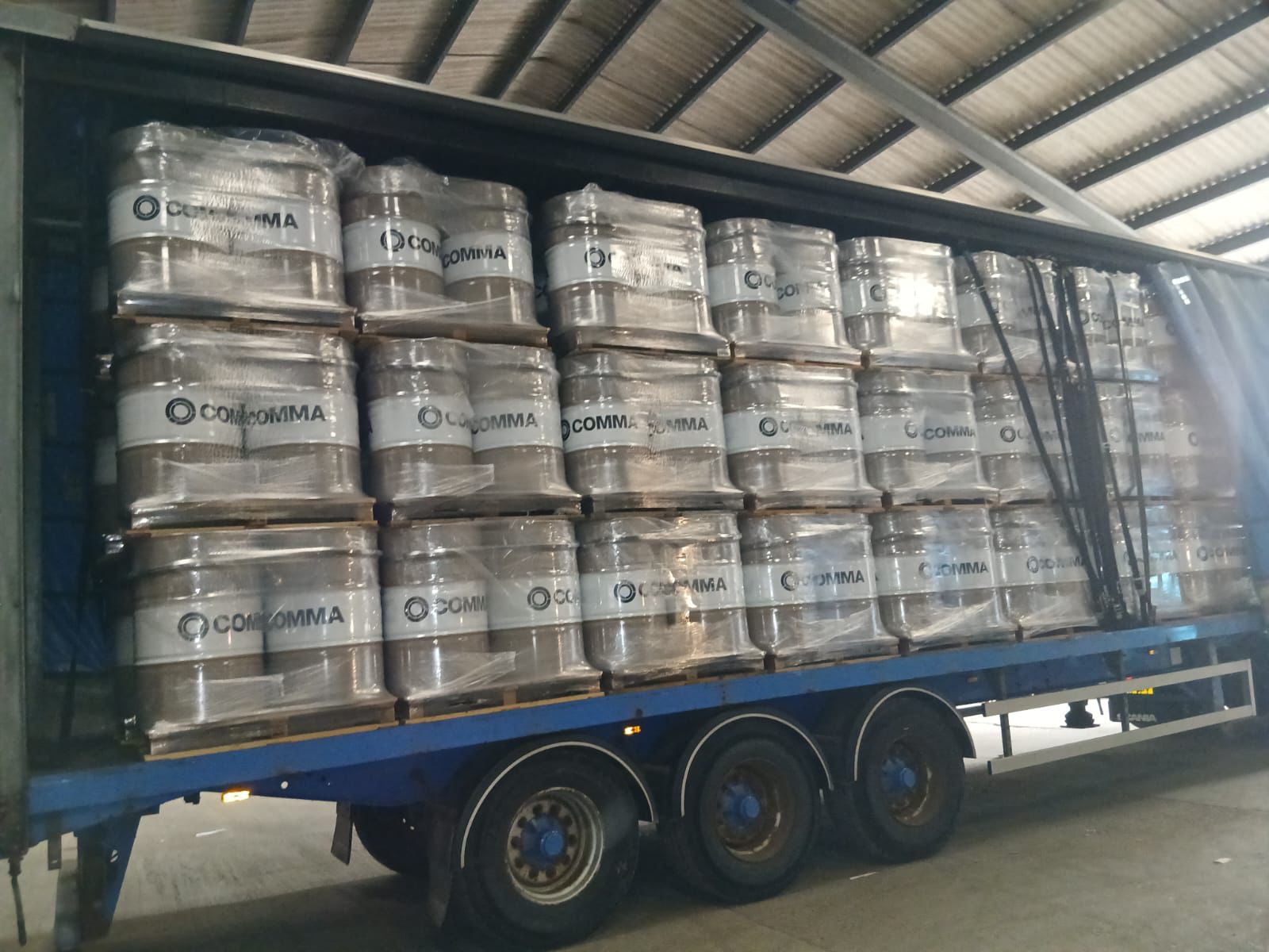 Articulated curtain-sider loaded with palletised drums